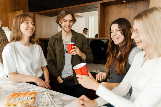 istock Happy colleagues talking at home enjoying drinks and snacks at dinning table 1774798739