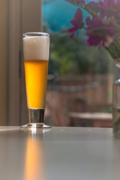 istock a beer glass on a table near some flowers on a windowsill 1774802561