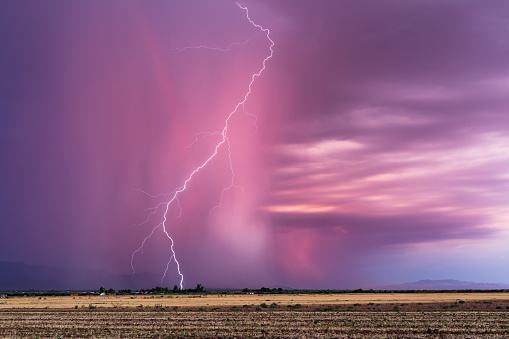A dramatic lightning bolt strike at sunset from a monsoon storm near Tucson, Arizona.