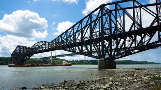 The Quebec Bridge is a combined road and rail bridge across the St. Lawrence River west of Quebec City. The Pierre Laporte Bridge (behind) is a road bridge over the St. Lawrence River, linking the cities of Quebec and Levis. It has the largest reach of all major Canadian suspension bridges.