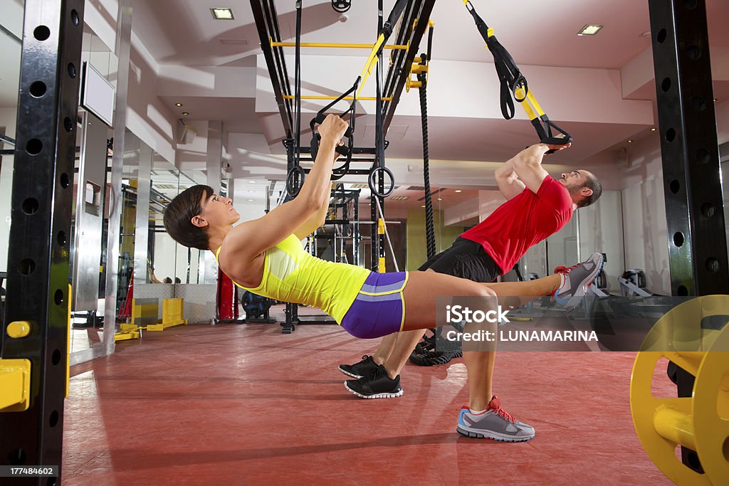 Man and woman training TRX fitness exercises at the gym gym fitness TRX training exercises at gym woman and man push-ups workout 20-29 Years Stock Photo
