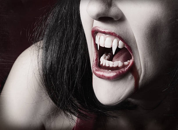 Vampire Teeth A close up of a female vampire's mouth with blood running our of it. vampire woman stock pictures, royalty-free photos & images