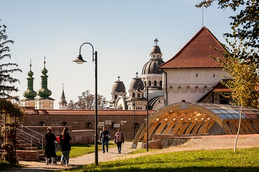 Oktober 12th 2019, Marosvasarhely, Transylvania: View from the internal court of Marosvasarhely' medieval citadel. One can see people having a walk , part of the wall and a tower. Further there are the towers of some emblematic buildings for the city, the Ascension of the Lord Orthodox Cathedral, Saint John the Baptist Church and the prefecture building in the background.