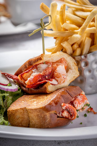 istock A lobster roll is a delectable seafood delicacy that exudes coastal charm and culinary excellence. It typically consists of succulent lobster meat, gently cooked and generously mixed with a light mayonnaise-based dressing. This flavorful lobster mixture i 1774904134