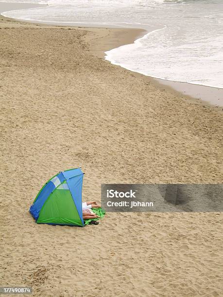 Photo libre de droit de Couple À Lintérieur De La Tente Avec Les Pieds À Lextérieur Sur La Plage banque d'images et plus d'images libres de droit de Abri de plage