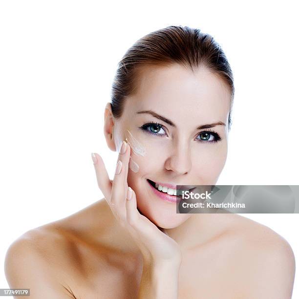 Happy Smiling Beautiful Woman Applying Moisturizer Cream On The Face Stock Photo - Download Image Now