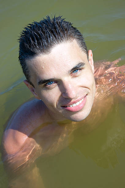 Młody człowiek uśmiech w wodzie – zdjęcie
