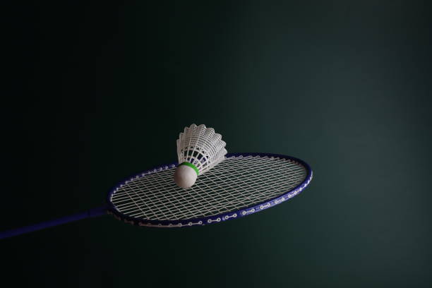 istock Playing badminton with a racket and shuttlecock in a dark green background. Yellow Shuttlecock in movement. 1774925716