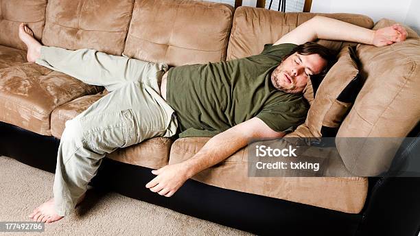 Lazy Guy Alejadas Todo El Sofá En La Sala De Estar Foto de stock y más banco de imágenes de Couch Potato - Refrán en inglés - Couch Potato - Refrán en inglés, Pereza, Acogedor