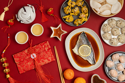 Chinese new year festival table over red background. Traditional lunar new year food. Flat lay, top view