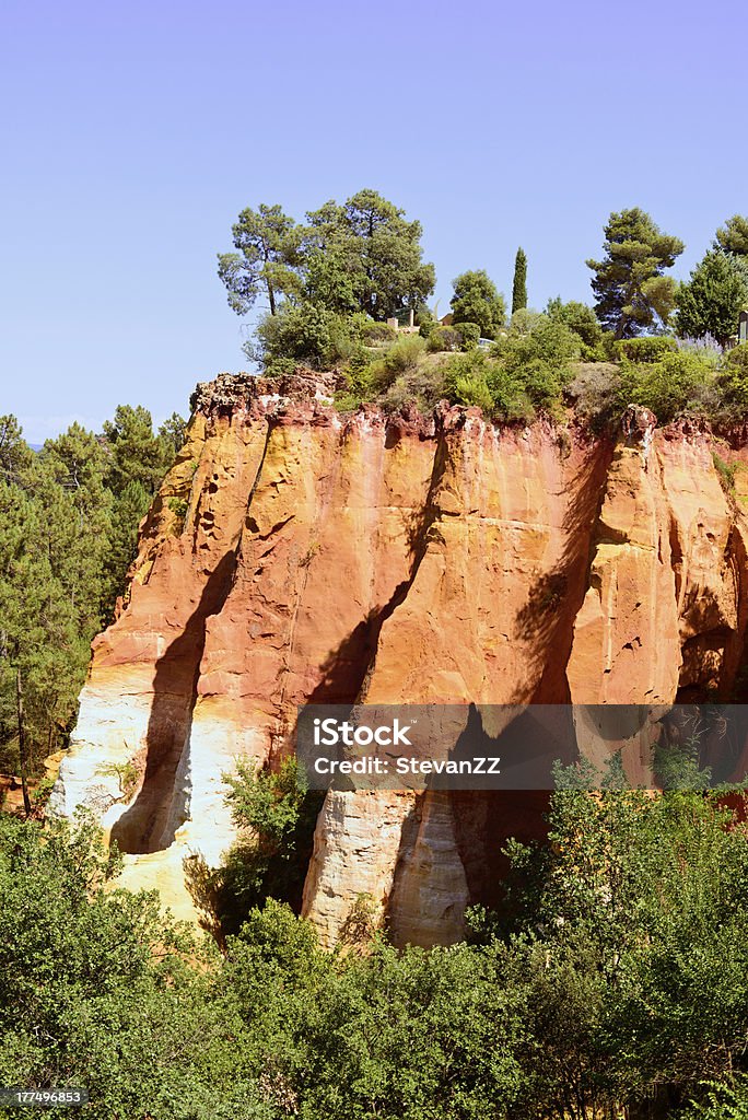Les Ocres du Roussillon, red rock formation. Luberon, Provence, France "Les Ocres du Roussillon, ochres red rock formation near footpath entrance. Luberon Natural Regional Park, Provence Cote Azur, France" Blue Stock Photo