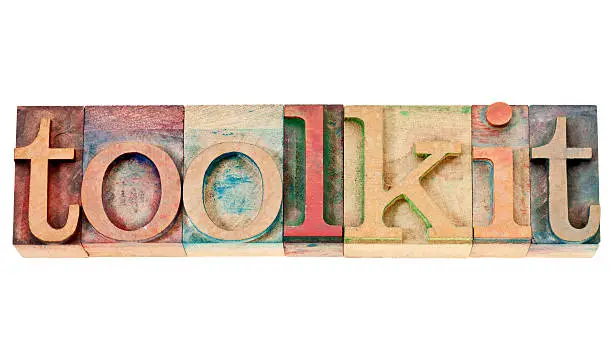 toolkit -  a set of tools or software -isolated word in vintage letterpress wood type stained by color inks isolated word in vintage letterpress wood type stained by color inks