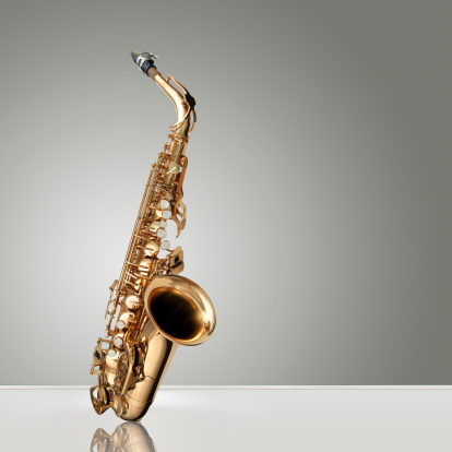 Alto Saxophone woodwind instrument over gray neutral background