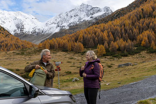 They are parked in a valley with larch trees on a mountain slope in autumn