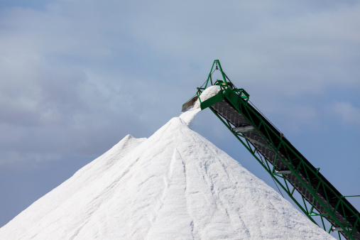 Extraction of salt. Salt mountains on blue sky.