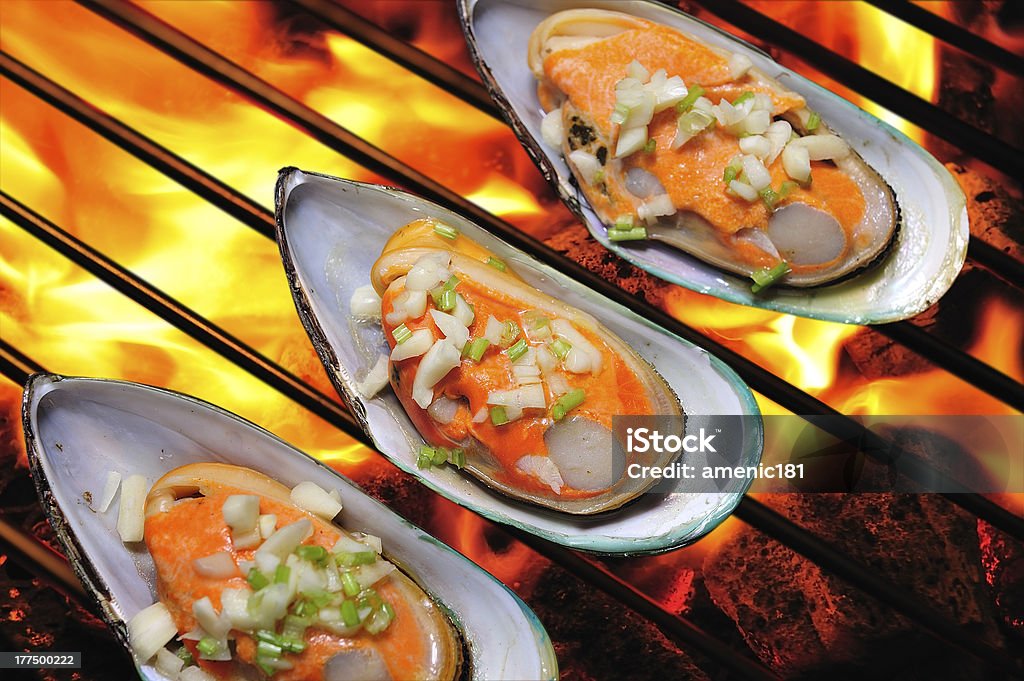 Grilled mussels "Grilled mussels topped with butter,garlic and parsley" Appetizer Stock Photo