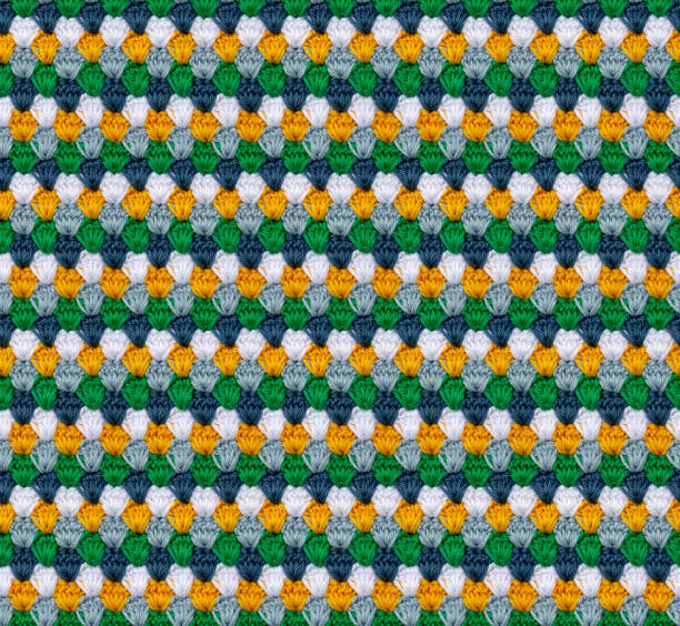 Seamless knitted texture in the form of flower buds. The pattern is crocheted from multicolored cotton yarn. Bright summer range of shades.