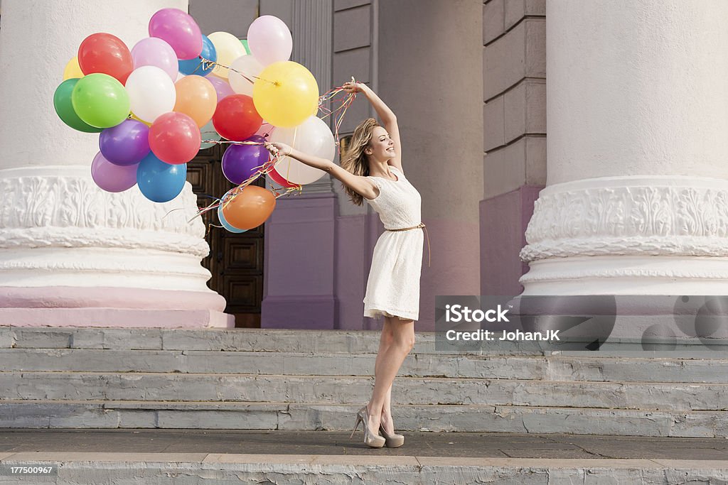 woman with balloons Young bridal with colorful latex balloons keeping her dress, urban scene, outdoors Balloon Stock Photo
