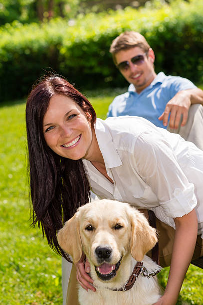 istock Couple sitting with golden retriever in park 177501558