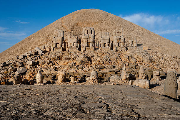East terrace Mount Nemrut. The east terrace of Mount Nemrut at sunrise with the Great alter in front of statues and the tumulus.  The UNESCO World Heritage Site at Mount Nemrut where King Antiochus of Commagene is reputedly entombed. nemrut dagi stock pictures, royalty-free photos & images