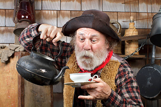 Old cowboy with kettle and china tea cup
