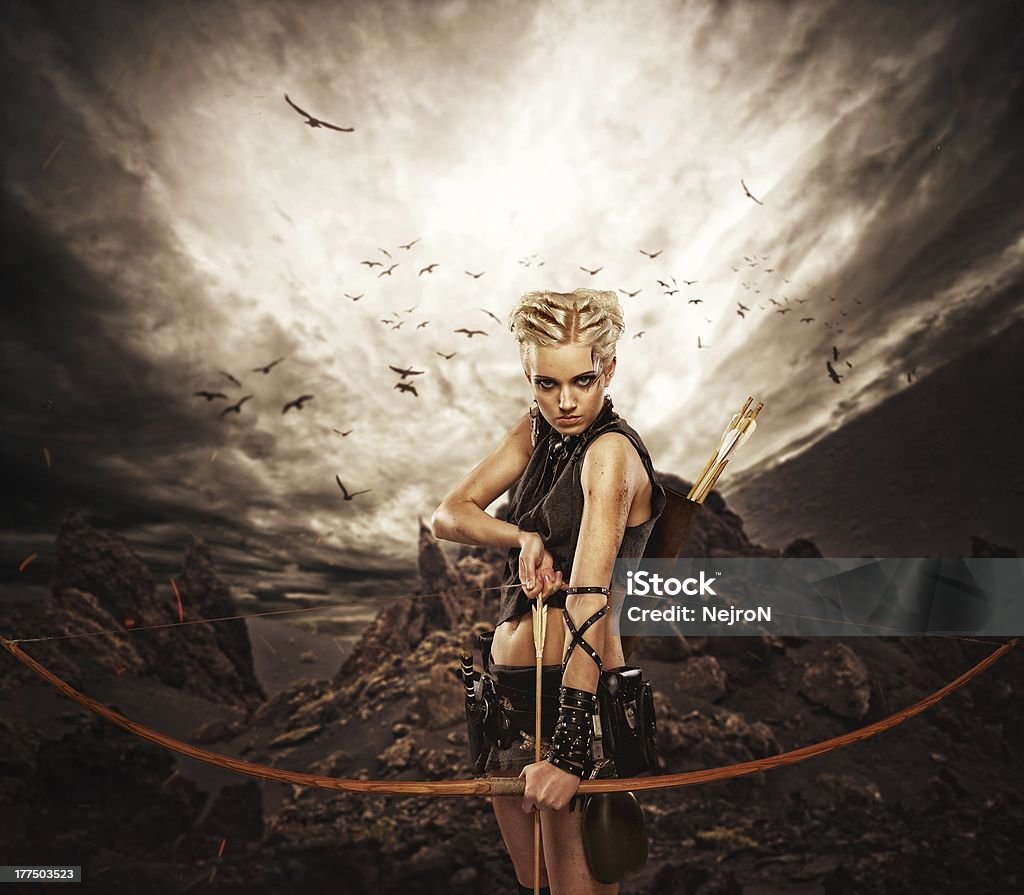 Mujer archer contra storm over rocks - Foto de stock de Tiro con arco libre de derechos