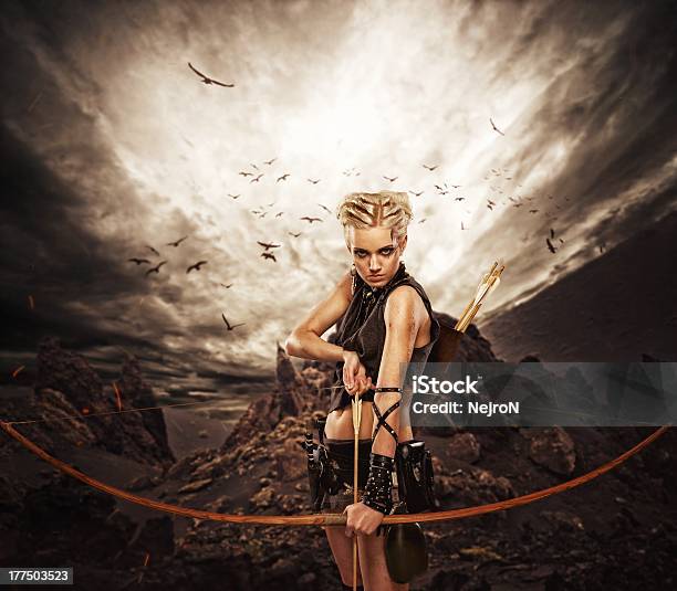 Mujer Archer Contra Storm Over Rocks Foto de stock y más banco de imágenes de Tiro con arco - Tiro con arco, Mujeres, Arco - Deporte