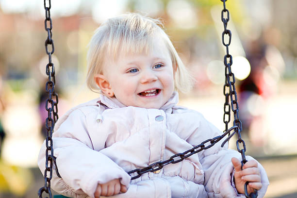A one year old girl on a swing