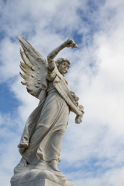 istock Angel statue holding rose against blue cloudy sky 177504170