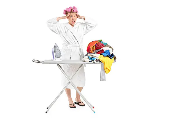 Photo of Annoyed housewife with ironing board and clothes