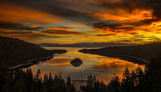 The sun rises behind mountains at Emerald Bay at Lake Tahoe