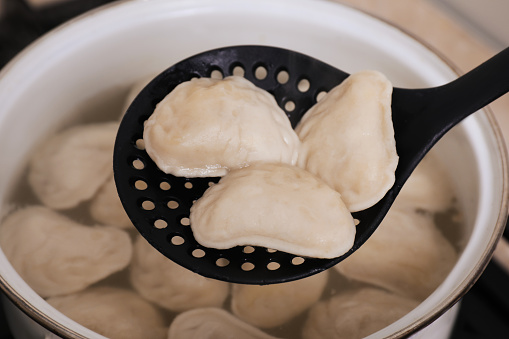 Authentic polish pierogi boiled to perfection, accompanied by caramelized onions on a plate, showcasing the savory and comforting qualities of this traditional dish.