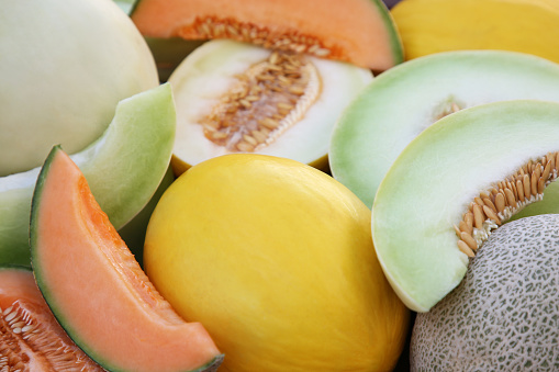Different types of tasty ripe melons as background, closeup