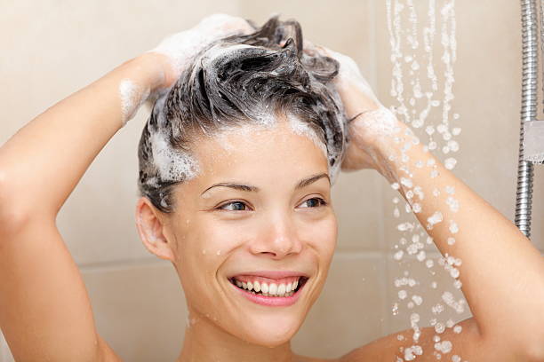 Woman washing hair Woman washing hair with shampoo foam in shower smiling happy looking at running warm water. Beautiful mixed race Asian Chinese / Caucasian female model in bathroom.Woman in shower washing hair with shampoo. washing hair stock pictures, royalty-free photos & images