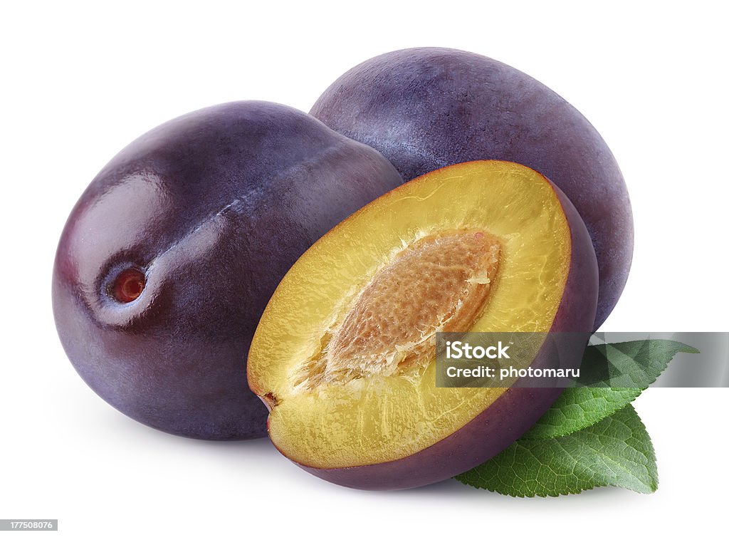 Purple plums one cut showing yellow inside and pit on white  More like this: Blue Stock Photo