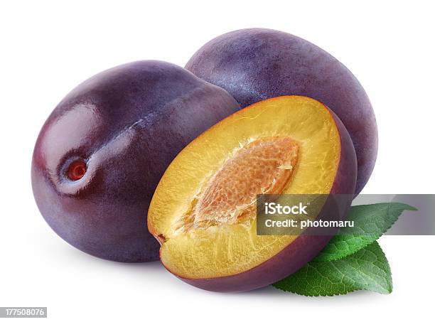 Purple Plums One Cut Showing Yellow Inside And Pit On White Stock Photo - Download Image Now