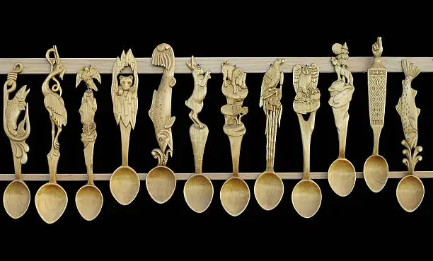 Sculpted wooden spoons isolated on black background. Romanian craft art.