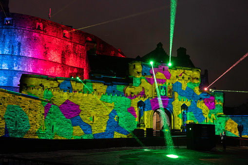 Edinburgh, Scotland, UK - December 10, 2022: Exterior of Edinburgh Castle illuminated with colorful lights during a free show during the Christmas season.
