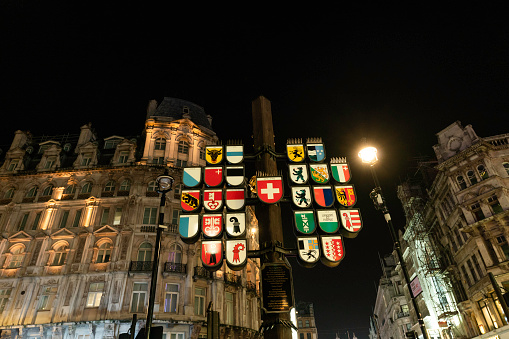 London, England, United Kingdom  - December 17, 2022: Switzerland Coat of Arms displayed in front of illuminated buildings in the city streets during the Christmas season