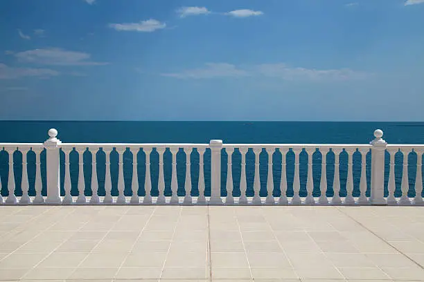 Summer view with classic white balustrade and empty terrace overlooking the sea (Italy)