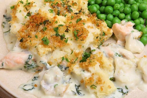Fish pie with peas on a wooden plate stock photo