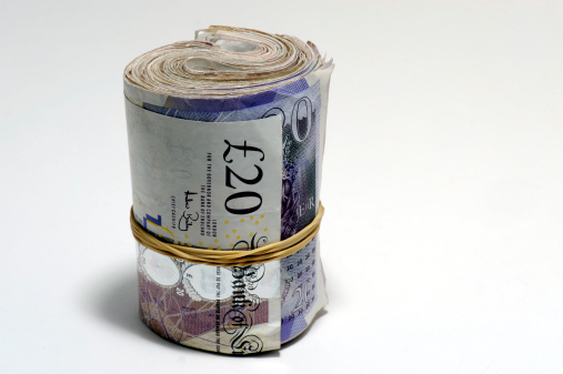 Dollar, Euro and British pound rolls on a black background