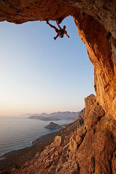 rock grimpeur au coucher du soleil - climbing mountain climbing rock climbing moving up photos et images de collection