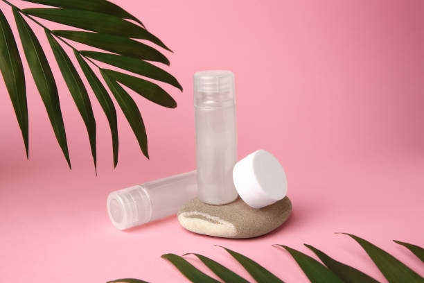 istock Cosmetic products, stone and palm leaves on pink background 1775100543