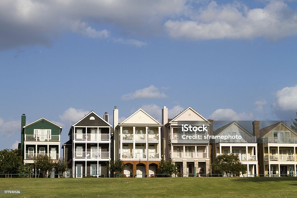 Exterior of a row of upscale townhouses with green grass Upscale townhomes for the wealthy built on a grass hill in a row against a cloudy blue sky in Memphis, Tennessee. Memphis - Tennessee Stock Photo
