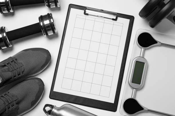istock Clipboard with workout plan and sports equipment on white background, flat lay. Personal training 1775102351