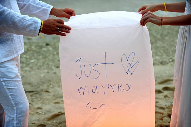 the wedding couple carrying lantern on the beach.