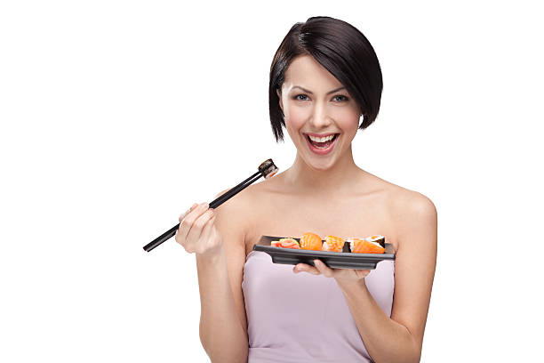 linda garota comendo sushi com hashis - chopsticks human hand women isolated - fotografias e filmes do acervo
