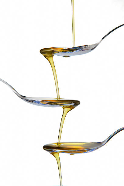 Spoons and olive oil falling stock photo