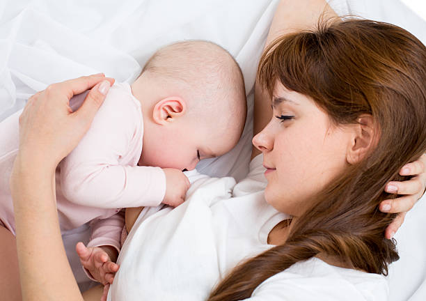 istock A mother breast-feeding her baby in bed 177512251